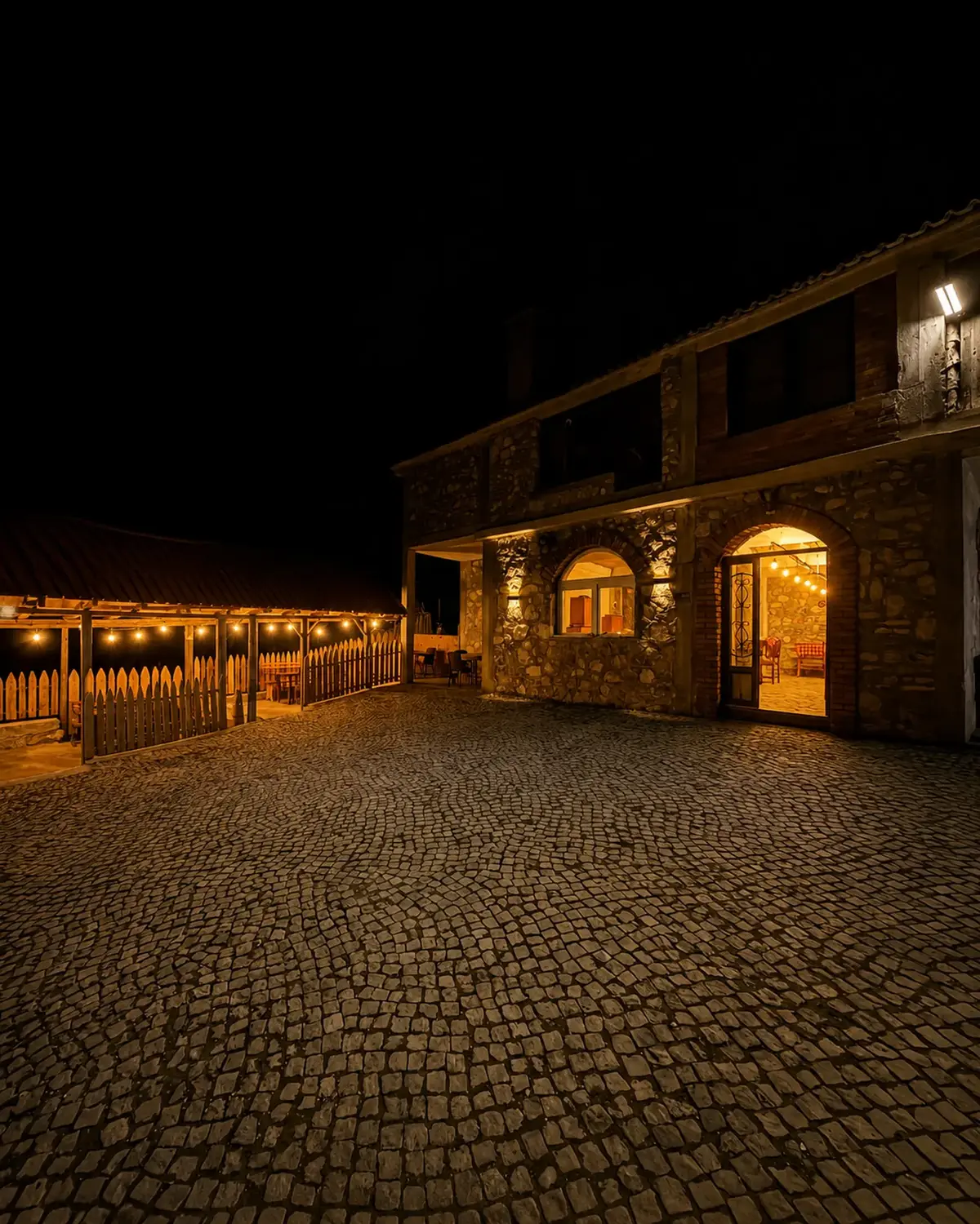 Restaurant Dardha në mbrëmje me dritat e ndezura